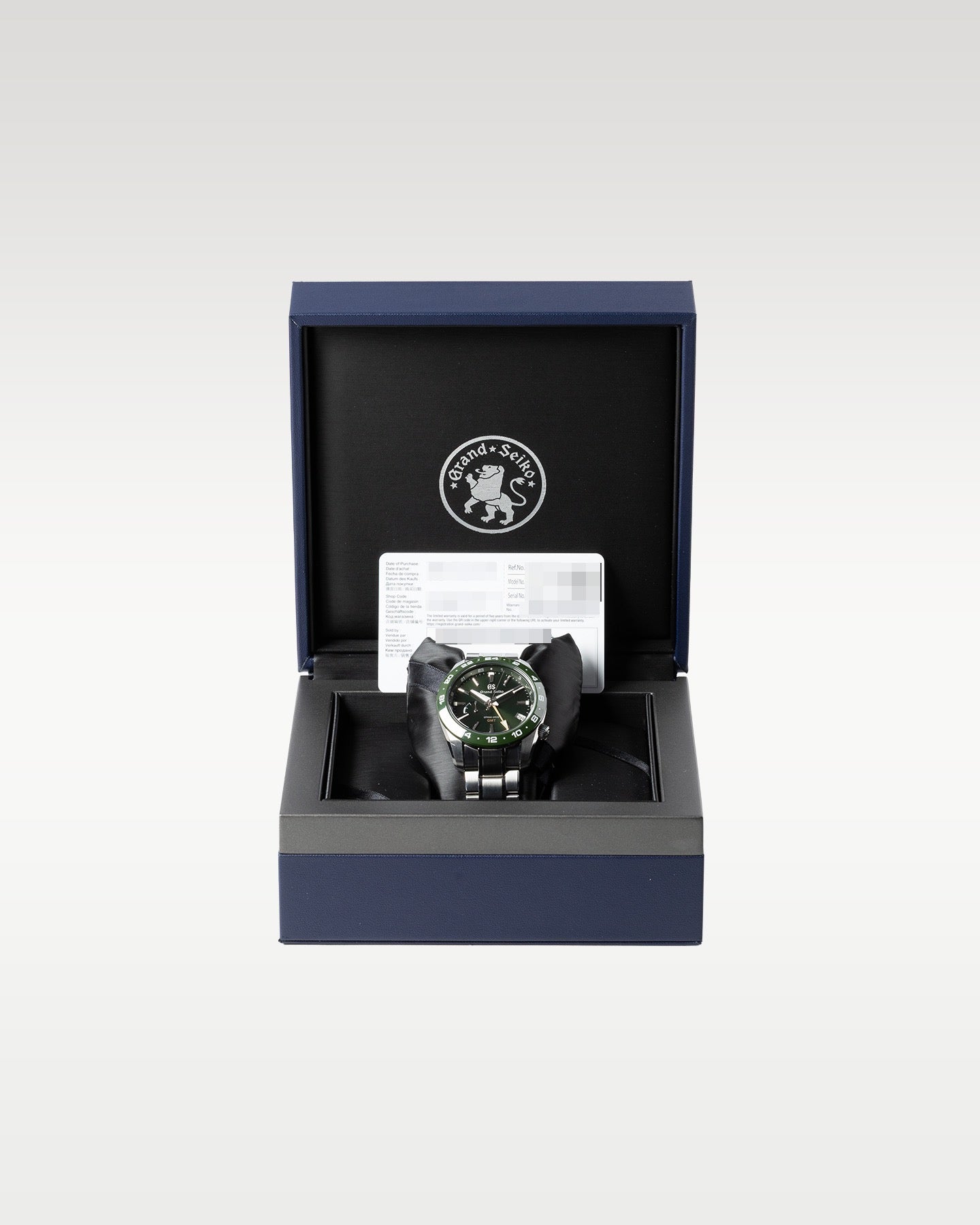 open luxury Grand Seiko inner presentation box lined with black plush fabric with a green SBGE257 watch