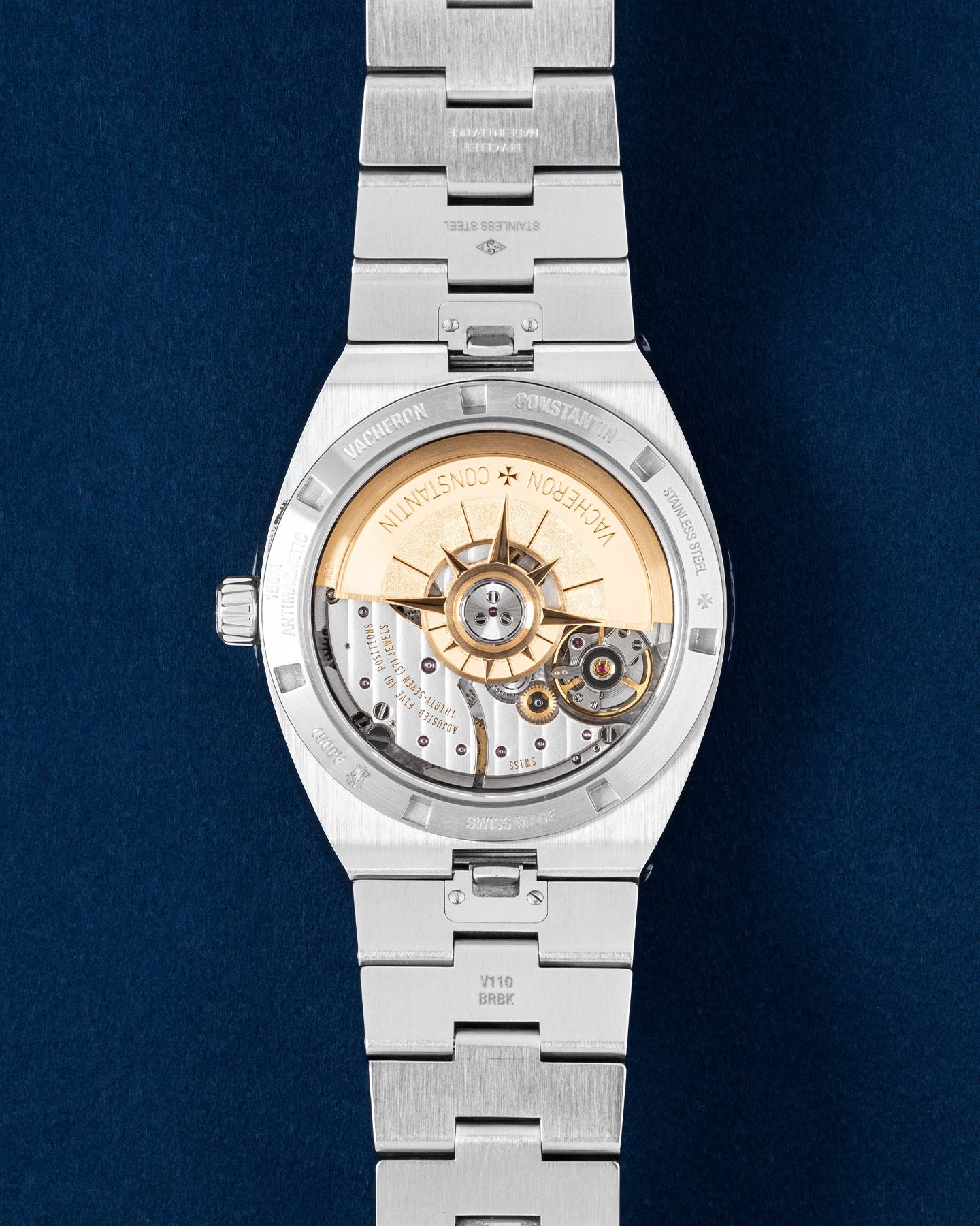 transparent sapphire exhibition caseback showing the automatic Calibre 5100 movement with a 22k yellow gold wind rose rotor