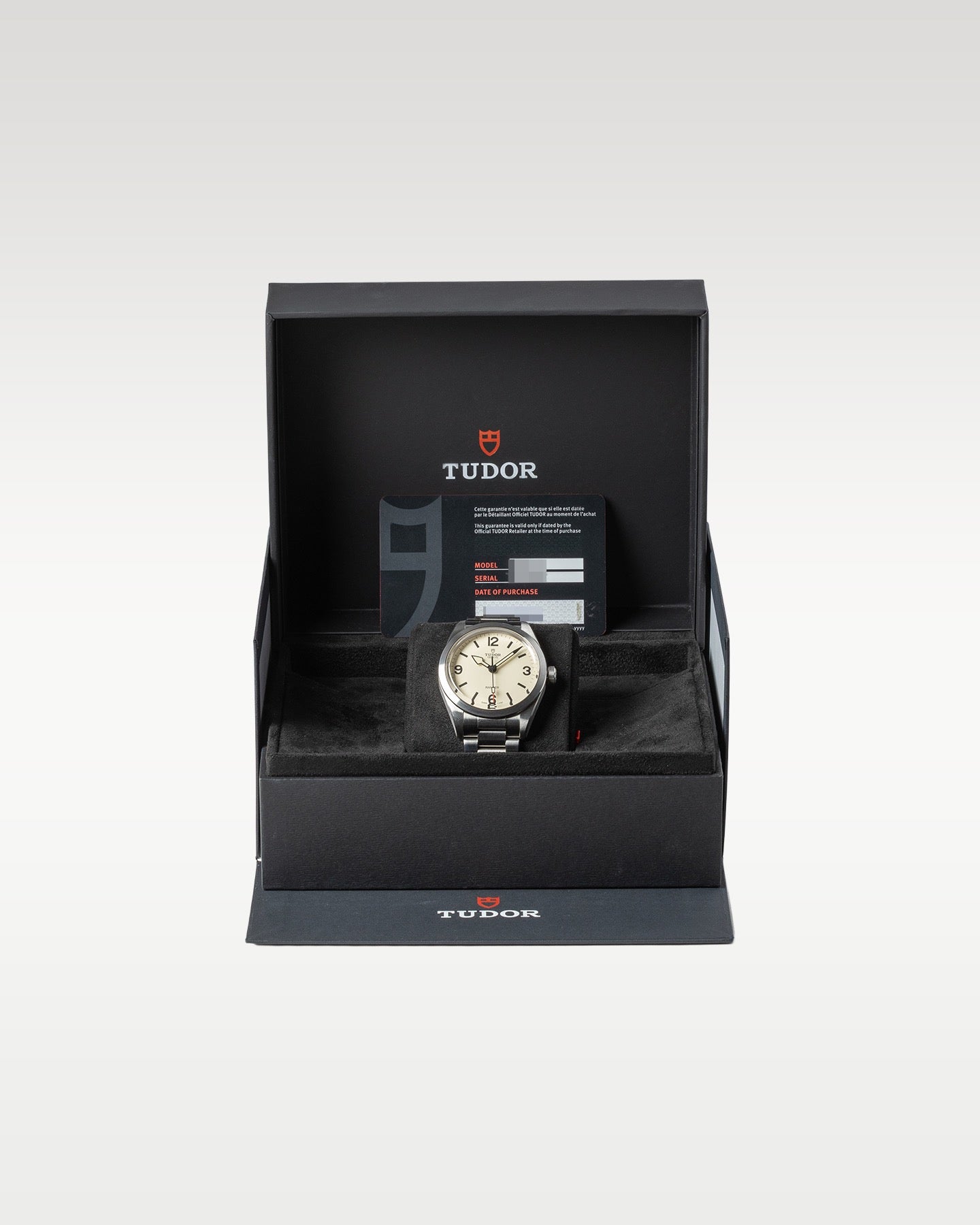 open black textured Tudor presentation box displaying a cream dial Ranger automatic field watch on a watch pillow