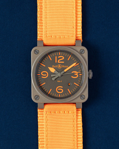 Brand new Bell and Ross BR03-92 MA-1 aviation watch featuring a matte military green ceramic square case and stenciled orange dial at Grand Caliber in Dallas