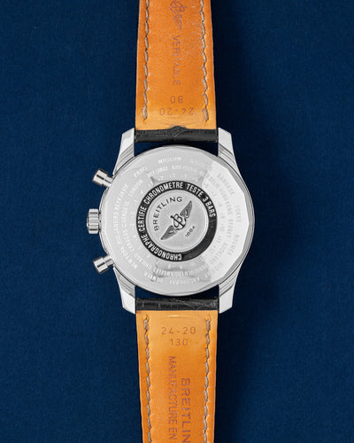 The reverse orientation of the polished stainless steel watch head highlighting the solid caseback deeply engraved with a convenient world time zone reference scale chart showing global offsets