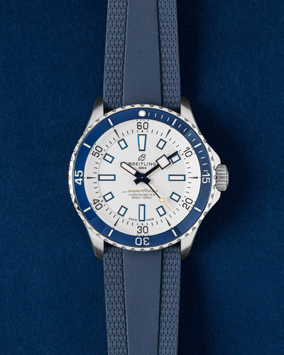 Breitling Superocean Automatic 42 watch featuring a white dial, contrasting dark blue ceramic bezel and a blue textured rubber strap