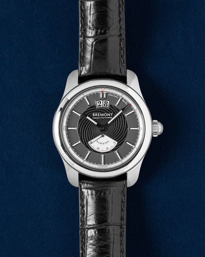 Bremont Hawking Limited Edition Hawking-SS-R-S stainless steel watch with a black spiral dial on a deep blue studio background