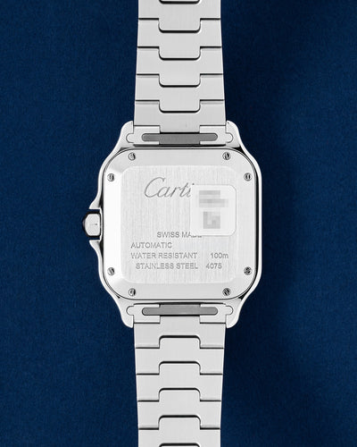 Close-up view of the engraved stainless steel caseback on a 2026 pre-owned Cartier Santos