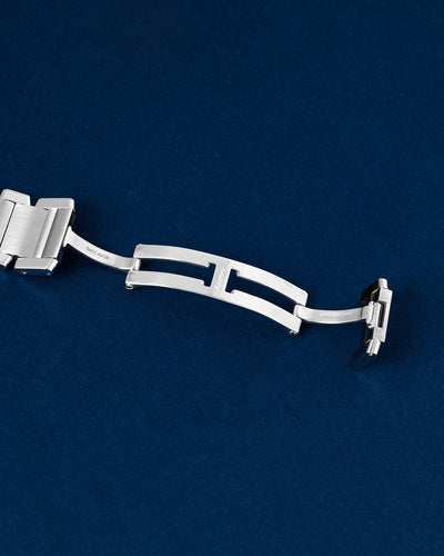Detailed view of the open double-folding hidden deployment butterfly clasp mechanism on a steel Cartier Tank Francaise watch bracelet