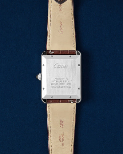 Engraved stainless steel caseback showing the automatic movement specs of a pre-owned Cartier Tank Solo XL