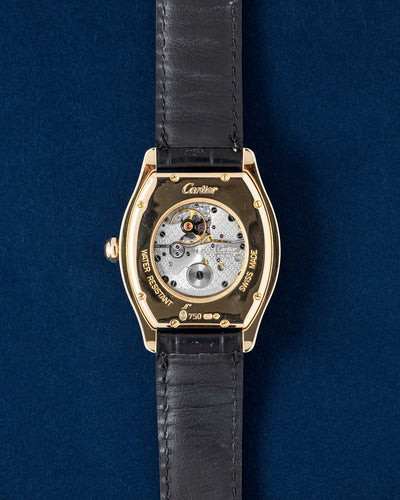 The sapphire crystal exhibition caseback of a gold Cartier Tortue showing the manual-wind caliber 437MC movement engraved with the Cartier interlocking C motif