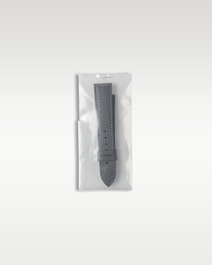 Additional secondary grained grey leather strap factory sealed in original protective plastic packaging