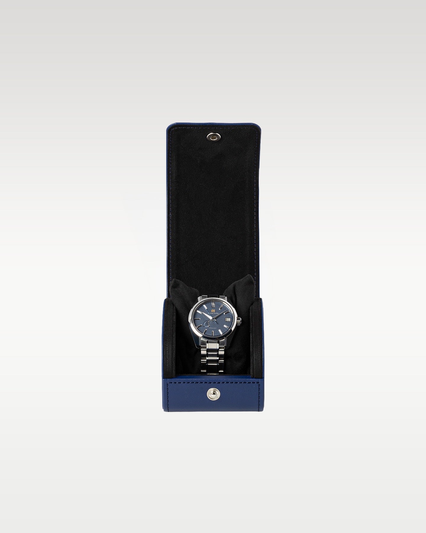 The complete secondary travel layout showing the ice blue Kirazuri dial watch secured inside an official black leather snap-button travel roll envelope
