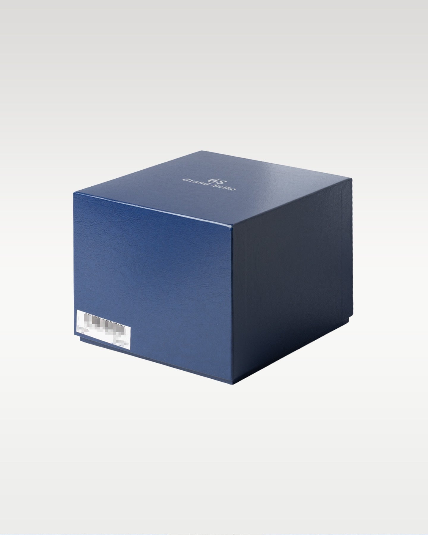 A three-quarter structural perspective of the deep blue protective cardboard outer box stamped with silver foil typography