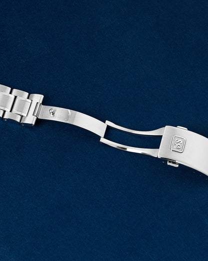 Open stainless steel deployant clasp mechanism on a Grand Seiko sport watch link bracelet