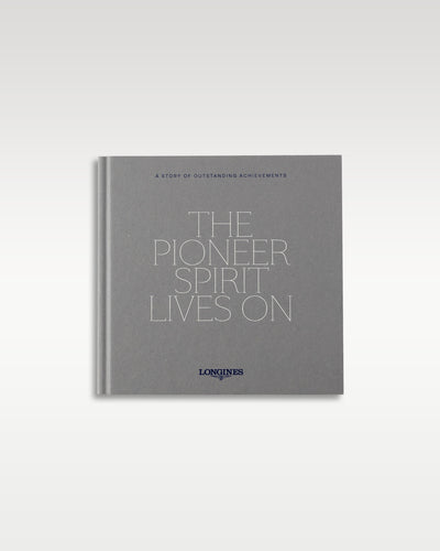 The official square gray Longines collector brand book titled 'The Pioneer Spirit Lives On' included in luxury packaging