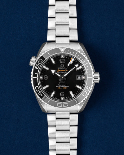 2017 Omega Seamaster Planet Ocean 43.5mm watch with a black ceramic dial and bezel on a deep blue studio background