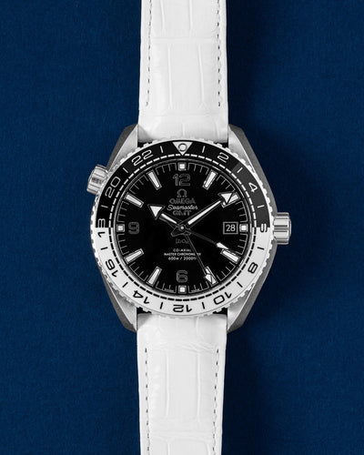 Pre-owned Omega Seamaster Planet Ocean 600M GMT Tai Chi 215.33.44.22.01.001 black and white ceramic bezel watch on white leather strap at Grand Caliber Dallas
