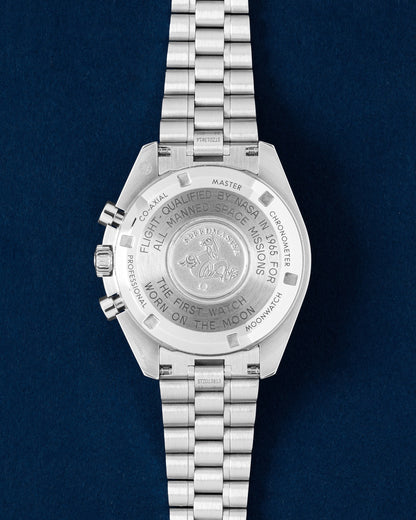 The solid stainless steel caseback of an Omega Speedmaster Moonwatch showing the official NASA flight-qualified engravings and Seahorse emblem