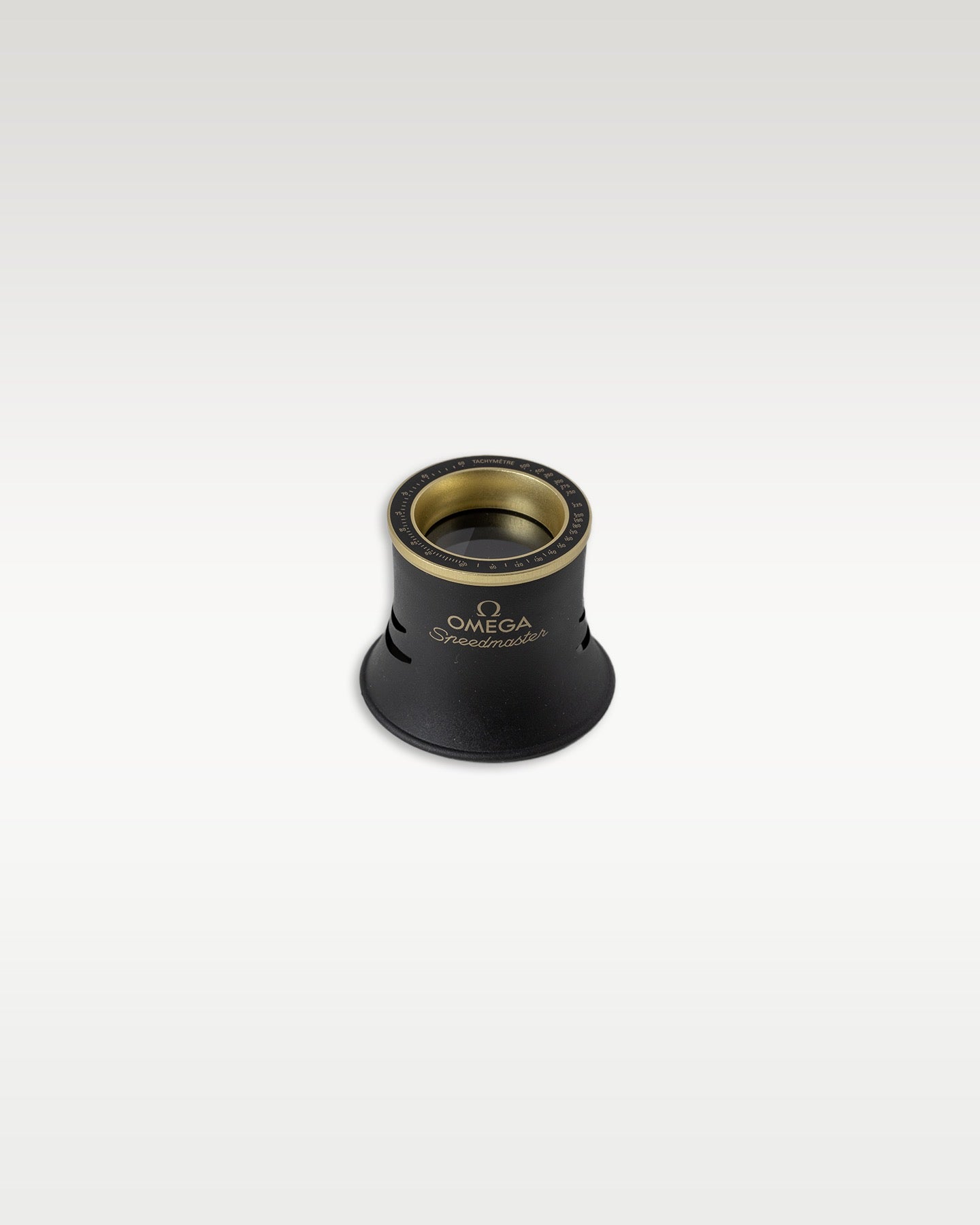 Branded Omega magnifying glass loupe eye piece with gold rim detailing for watch inspection