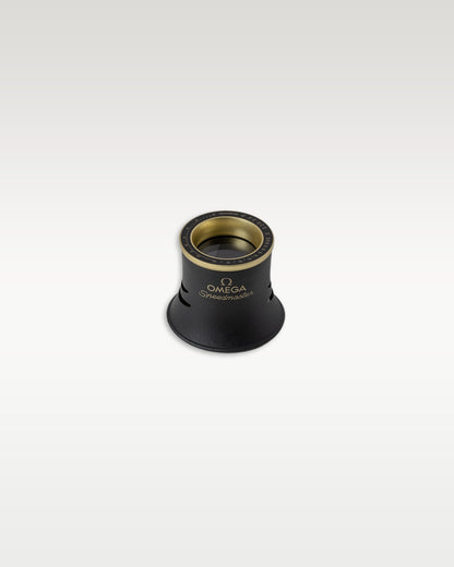 Branded Omega magnifying glass loupe eye piece with gold rim detailing for watch inspection