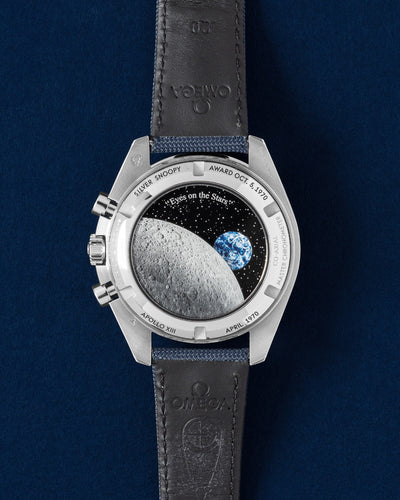 The magical reverse caseback displaying a photorealistic moon surface, a spinning earth disc, and the animated mechanical Snoopy in his Apollo command module