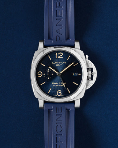 Pre owned 2019 Panerai Luminor GMT 44mm PAM01033 blue sunburst dial steel watch on blue rubber strap at Grand Caliber Dallas