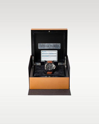 The complete retail collector presentation layout showing the Panerai Luminor Marina Logo PAM 00005 watch resting inside its inner natural wood luxury display chest with documents attached to the inner lid at Grand Caliber in Dallas, Texas