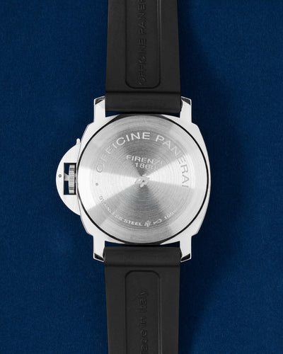 Panerai Luminor case showing the solid circular brushed and polished stainless steel caseback attached to a black rubber strap
