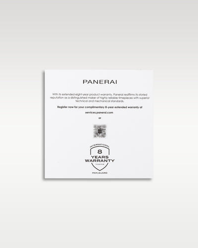 A flat lay shot of the white paper informational insert detailing the complimentary extended eight year warranty for the Panerai Submersible PAM01229 at Grand Caliber in Dallas, Texas