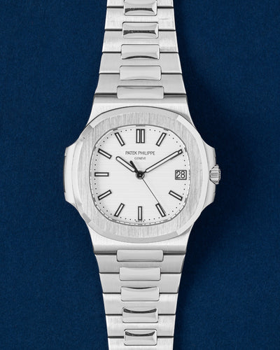 A preowned 2014 Patek Philippe Nautilus 5711 displaying its original textured white dial silver tone hands and signature integrated stainless steel case at Grand Caliber in Dallas, Texas