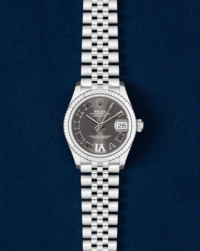 Brand new 2026 Rolex Datejust 31 278274 watch with a slate gray Roman numeral dial and 18k white gold fluted bezel on a navy blue studio background