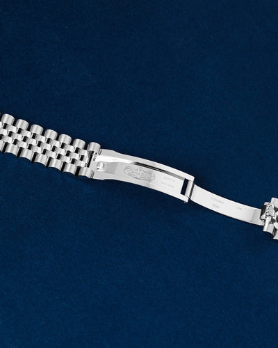 Close-up studio view of the open Rolex concealed folding clasp mechanism showing inner hallmark and crown engravings