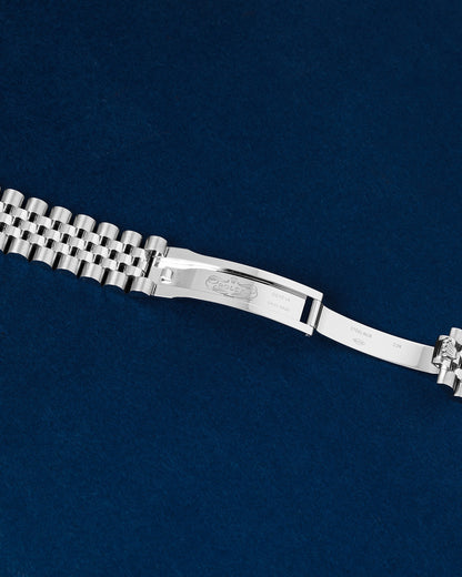 Close-up studio view of the open Rolex concealed folding clasp mechanism showing inner hallmark and crown engravings