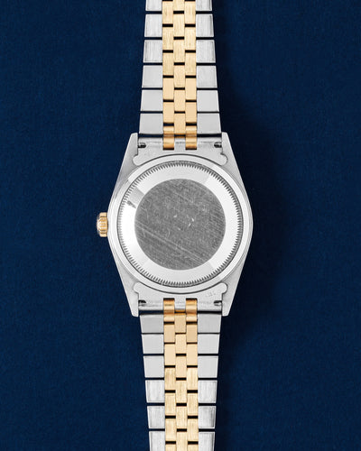 Rear studio view of the 36mm Rolex Datejust case showing the brushed solid caseback and the two-tone steel and 18k yellow gold five-link Jubilee bracelet