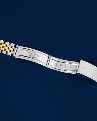 flat top-down view of the internal stainless steel folding clasp blades and hinge mechanism of a vintage-style Rolex Jubilee bracelet open over a navy background