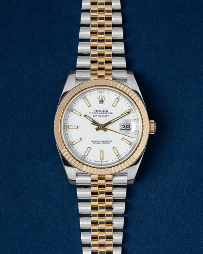 A preowned 2023 Rolex Datejust 41 reference 126333 in two-tone yellow Rolesor featuring a bright white dial with luminous stick index markers at Grand Caliber in Dallas