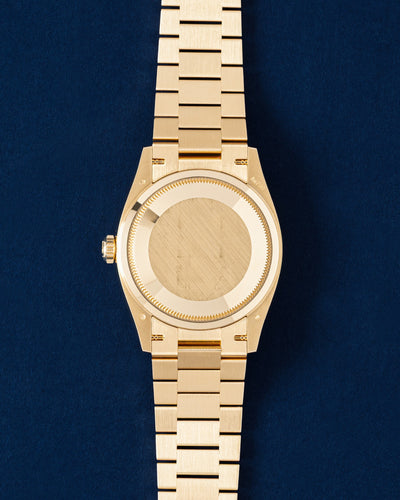 Rear studio view of the solid gold 36mm Rolex Day-Date case showing the brushed gold caseback and three-link semicircular President bracelet links
