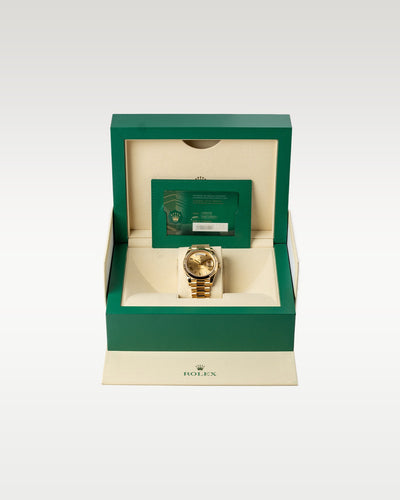 The complete retail collector packaging showing the solid gold 2022 Presidential timepiece secured inside its inner green wave-motif presentation display chest with documentation