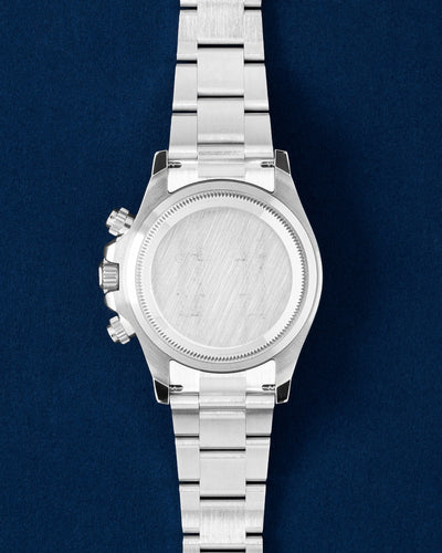 The solid Oystersteel caseback profile view of a Rolex Daytona 126500LN showing the signature screw-down chronograph pushers and crown