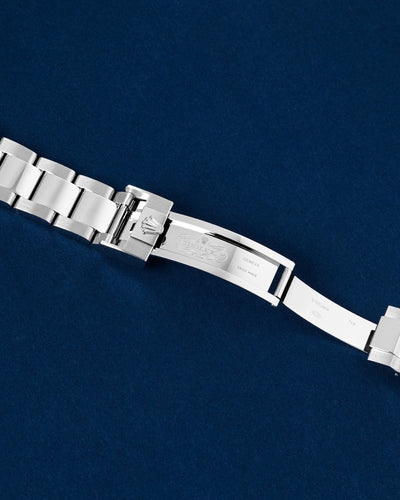 Close-up studio view of the open Rolex Oysterlock safety folding clasp mechanism showing inner metal hallmark engravings