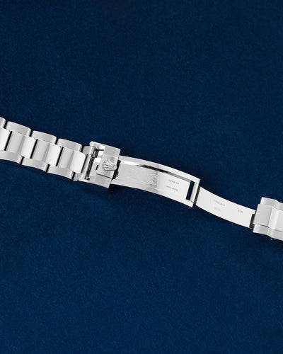 Close-up studio view of the open Rolex Oysterlock safety folding clasp mechanism showing internal metal hallmark engravings