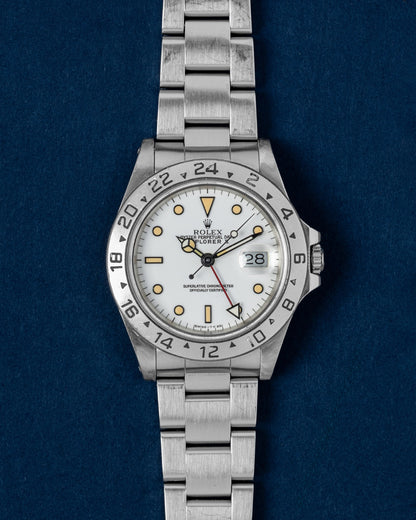 A vintage 1991 Rolex Explorer II reference 16570 featuring its iconic polar white dial, contrasting black-trimmed creamy tritium hour markers, and red GMT hand at Grand Caliber in Dallas