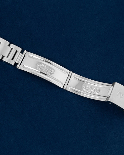 flat lay shot of the interior folding blades of the open stainless steel Oyster bracelet showing the official vintage Rolex registered design factory stamps