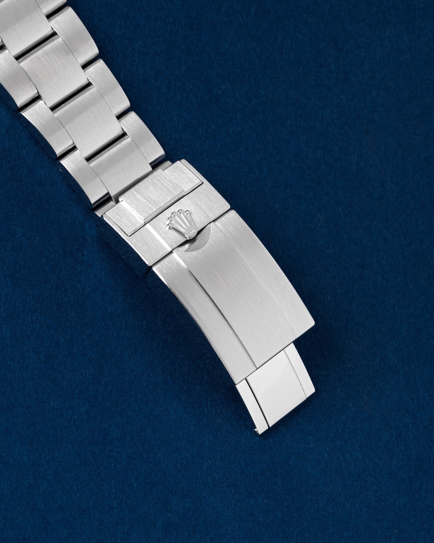exterior view of a brushed Oystersteel Oysterlock folding safety clasp with an embossed Rolex crown logo