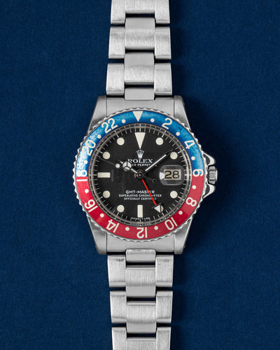 A vintage 1977 Rolex GMT-Master reference 1675 displaying its original matte black dial, tritium hour plots, and an authentic faded red and blue aluminum Pepsi bezel insert at Grand Caliber in Dallas