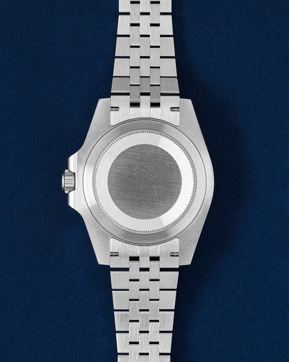 Solid brushed stainless steel screw-down Oyster caseback on a pre-owned Rolex GMT-Master II Batgirl watch