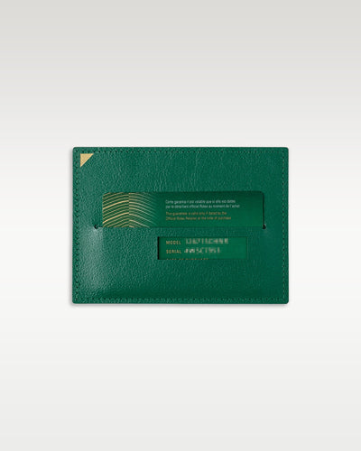 A top-down view of the classic green textured leather vertical sleeve wallet used to safely house the official international registration guarantee card