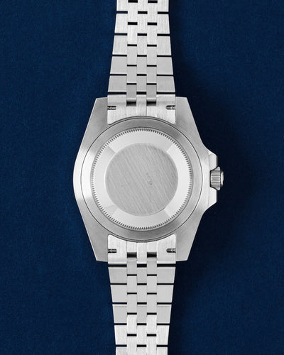 The solid Oystersteel caseback profile view of a left-handed Rolex GMT-Master II Sprite displaying the d-shaped link Jubilee bracelet