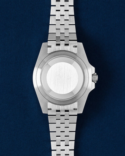 Clean brushed stainless steel screw-down Oyster caseback on a pre-owned Rolex GMT-Master II Sprite
