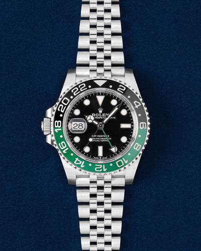 2024 Rolex GMT-Master II 126720VTNR Sprite left-handed watch featuring a green and black ceramic bezel and Jubilee bracelet on a navy blue studio background