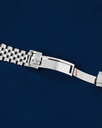 Close-up studio view of the open Rolex Jubilee folding Oysterlock safety clasp mechanism showing inner metal hallmark engravings