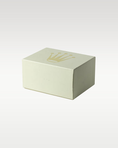 structural perspective of the classic off-white cream cardboard outer box sleeve detailed with the minimalist embossed gold Rolex crown logo