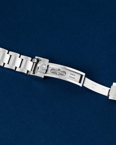 Close up flat lay shot of the interior folding blades and Easylink extension mechanism of the open stainless steel deployment clasp against a dark blue surface